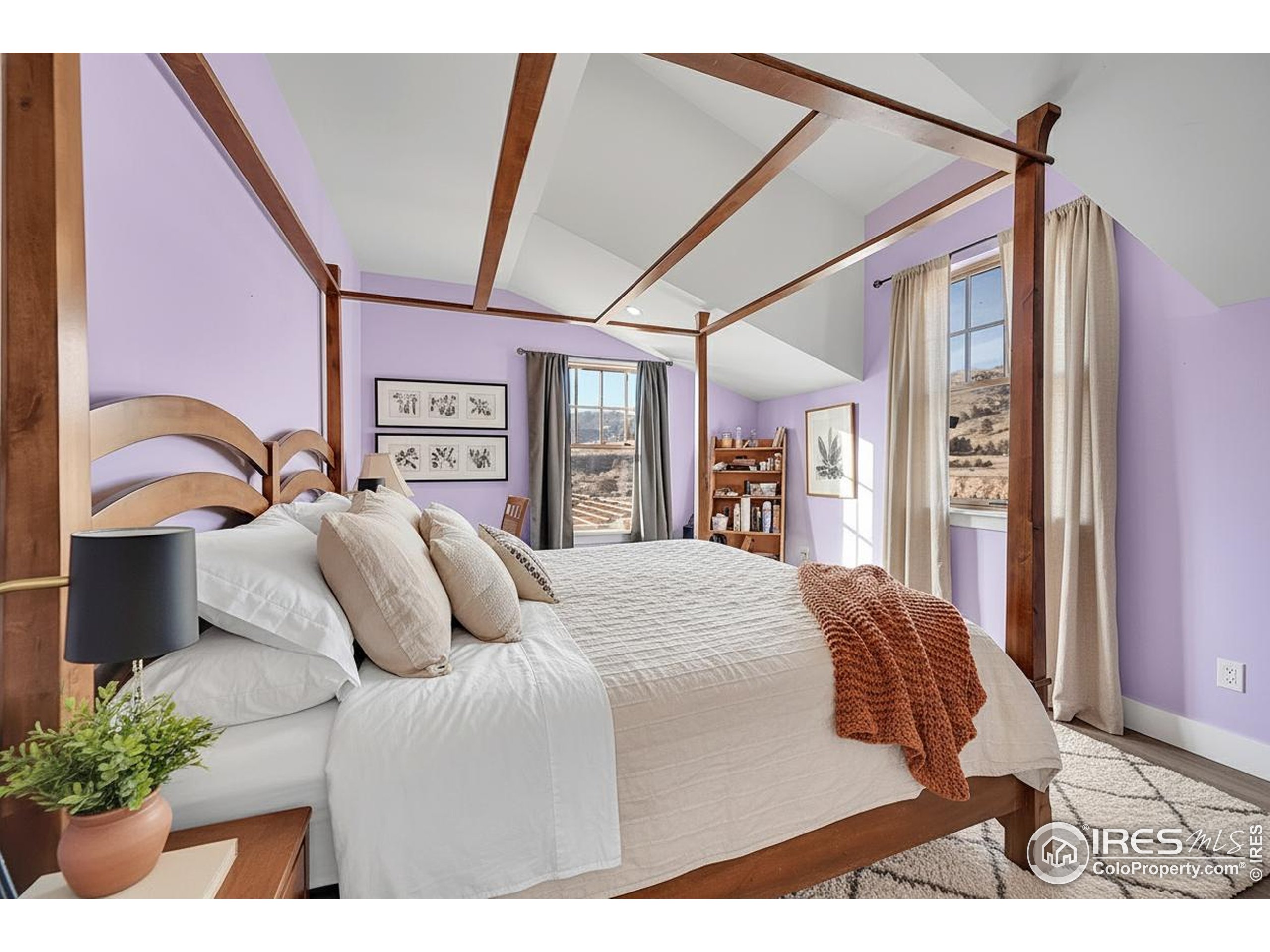 702 Ponderosa Hill Road Lyons, CO 80540 - Photo 24 of 39 a bedroom with a large bed and a chandelier