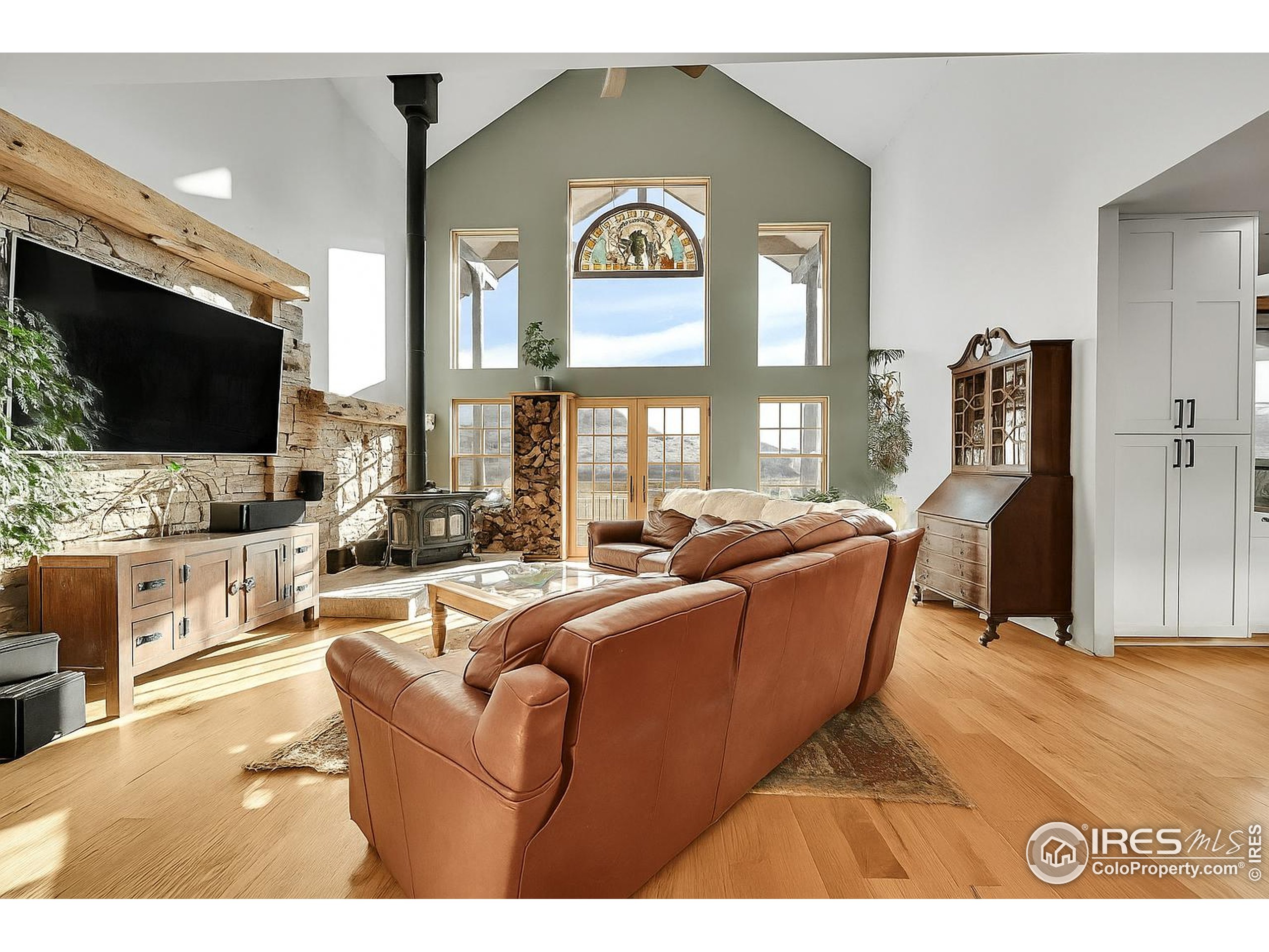 702 Ponderosa Hill Road Lyons, CO 80540 - Photo 6 of 39 a living room with furniture a flat screen tv and a chandelier