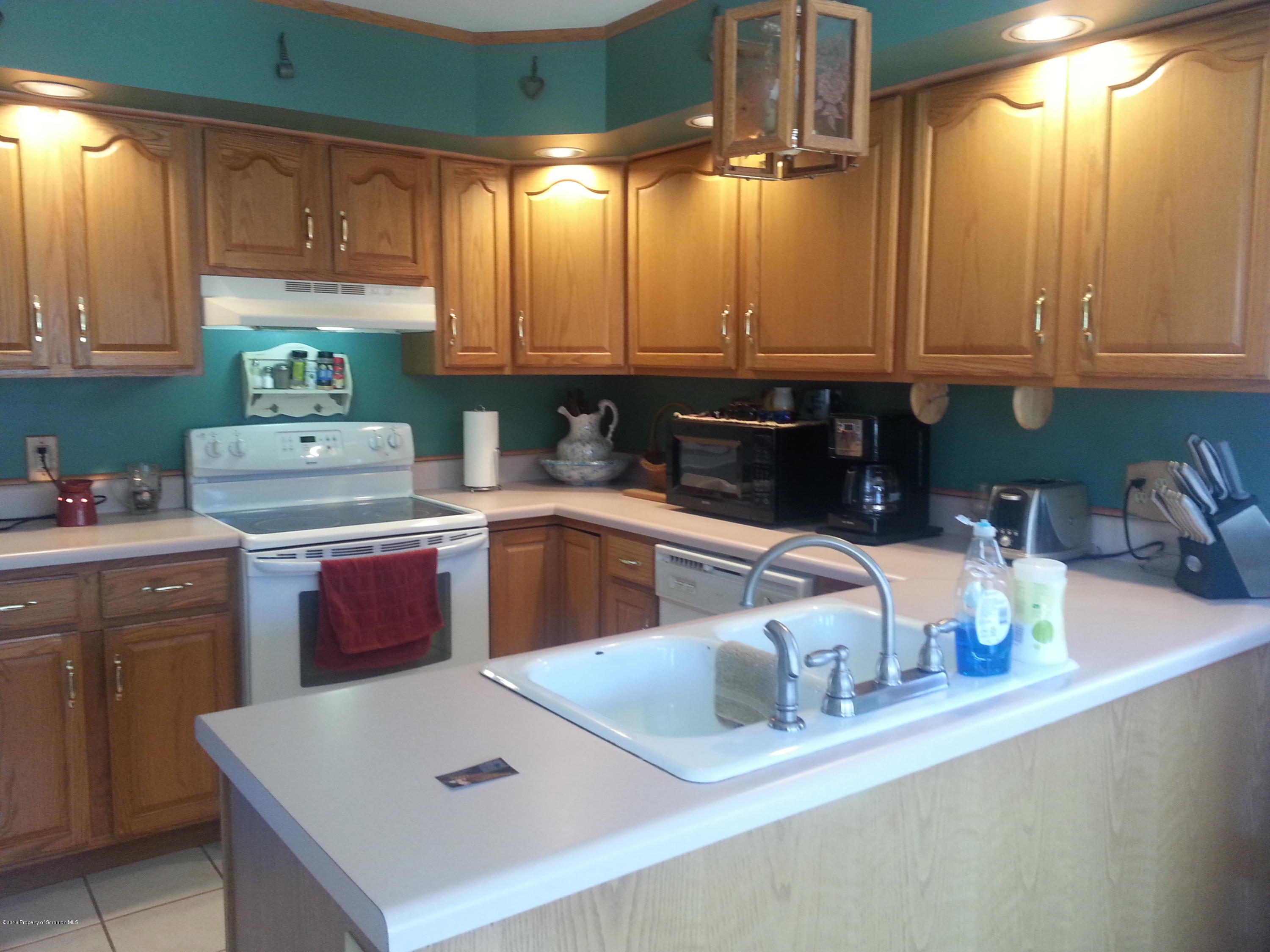 9021 State Rte 6 Meshoppen, PA 18630 - Photo 2 of 16 a kitchen with kitchen island granite countertop a sink a stove and cabinets