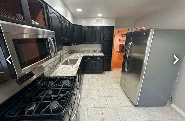 a kitchen with stainless steel appliances a sink stove and refrigerator