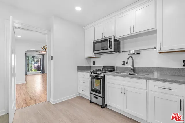 a kitchen with granite countertop cabinets stainless steel appliances and a sink