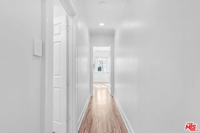 a view of a hallway with wooden floor