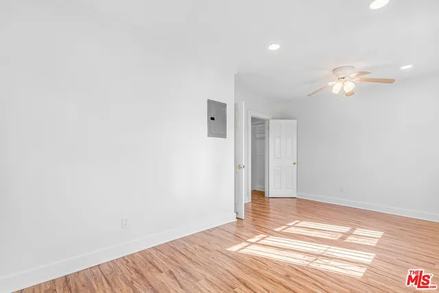 a view of a room with wooden floor and ceiling fan