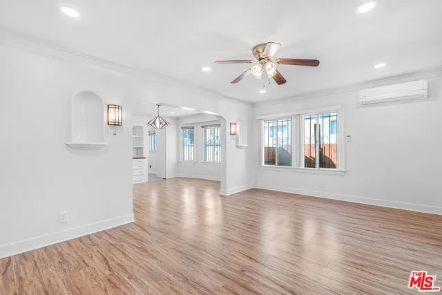 a view of an empty room with window and wooden floor