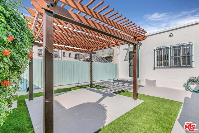 a patio with table and chairs and potted plants
