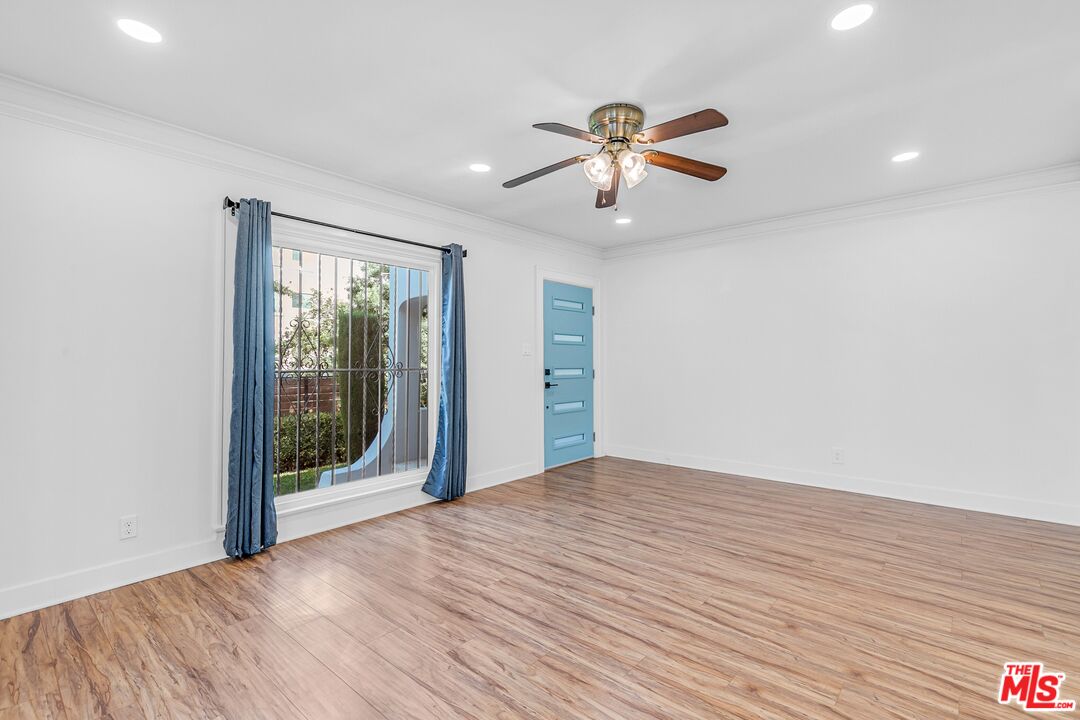 123 North Reno Street Los Angeles, CA 90026 - Photo 3 of 28 a view of empty room with wooden floor and fan