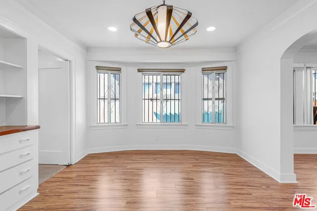 a view of empty room with window and wooden floor