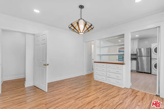 a view of kitchen and front door with wooden floor