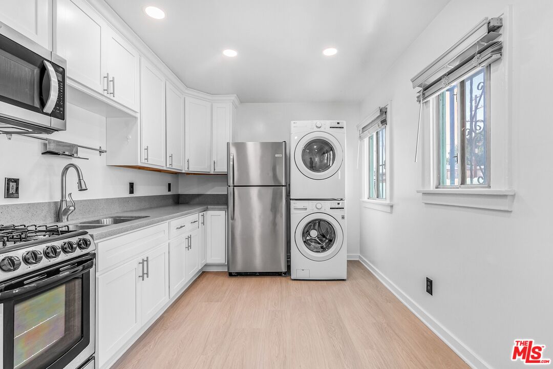 123 North Reno Street Los Angeles, CA 90026 - Photo 10 of 28 a kitchen with a stove top oven sink and cabinets