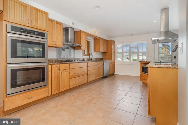 a kitchen with stainless steel appliances granite countertop a stove top oven a sink dishwasher and cabinets