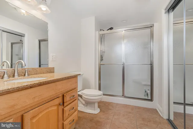 a bathroom with a granite countertop sink toilet and shower