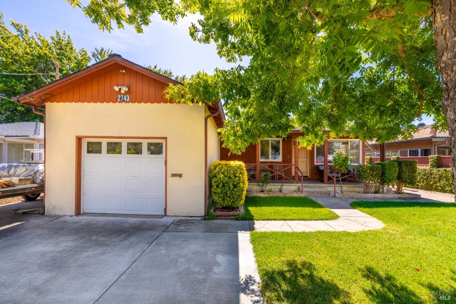 a front view of a house with a yard garage and outdoor seating