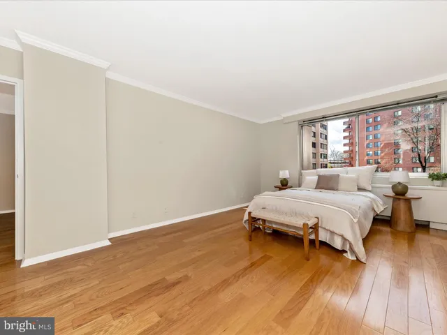 a spacious bedroom with a bed and wooden floor