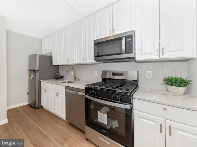 a kitchen with white cabinets and stainless steel appliances