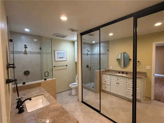 a bathroom with a granite countertop sink mirror and shower