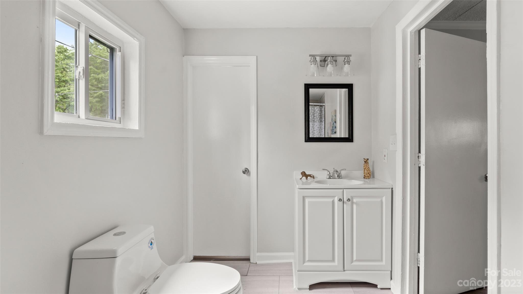 705 Sumter Street Lancaster, SC 29720 - Photo 9 of 16 a bathroom with a toilet a sink and mirror