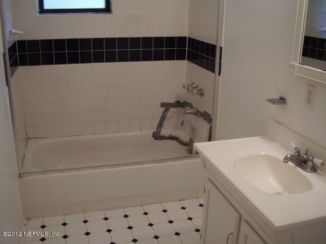 5721 Beney Road Jacksonville, FL 32207 - Photo 10 of 11 a bathroom with a sink a toilet and a mirror