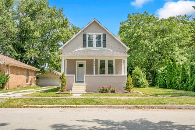 a front view of a house with a garden and yard