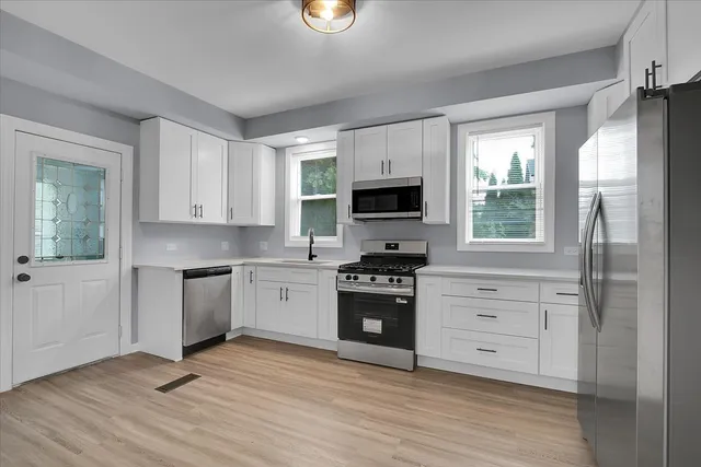 a kitchen with granite countertop a stove a sink and a refrigerator
