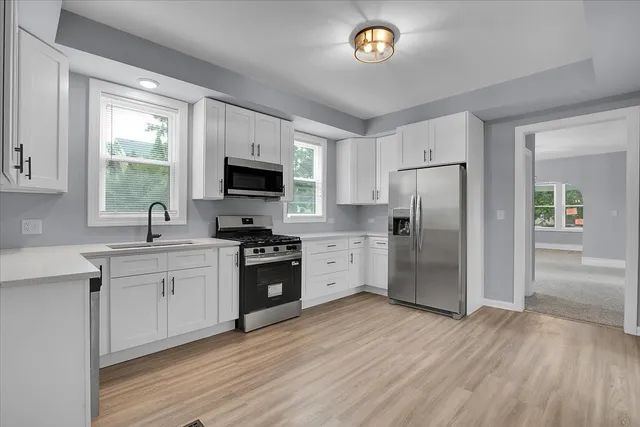 a kitchen with granite countertop a refrigerator stove top oven and sink