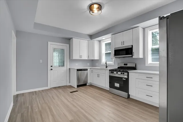 a kitchen with a refrigerator and a stove top oven