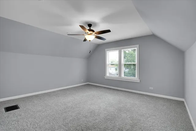 an empty room with a window and a ceiling fan