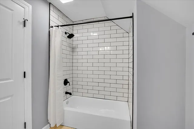 a bathroom with a shower and a bath tub