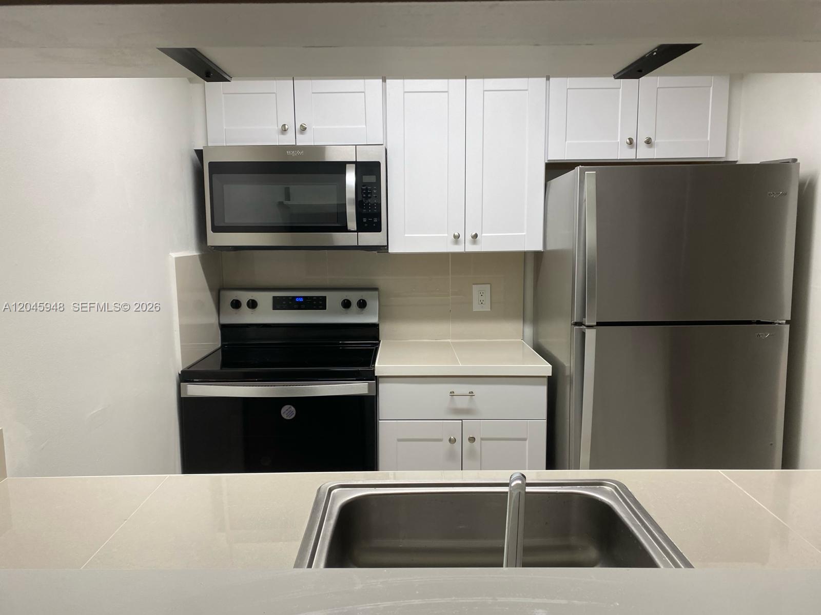 5612 Rock Island Road, Unit 167 Tamarac, FL 33319 - Photo 3 of 16 a kitchen with a sink a stove and refrigerator