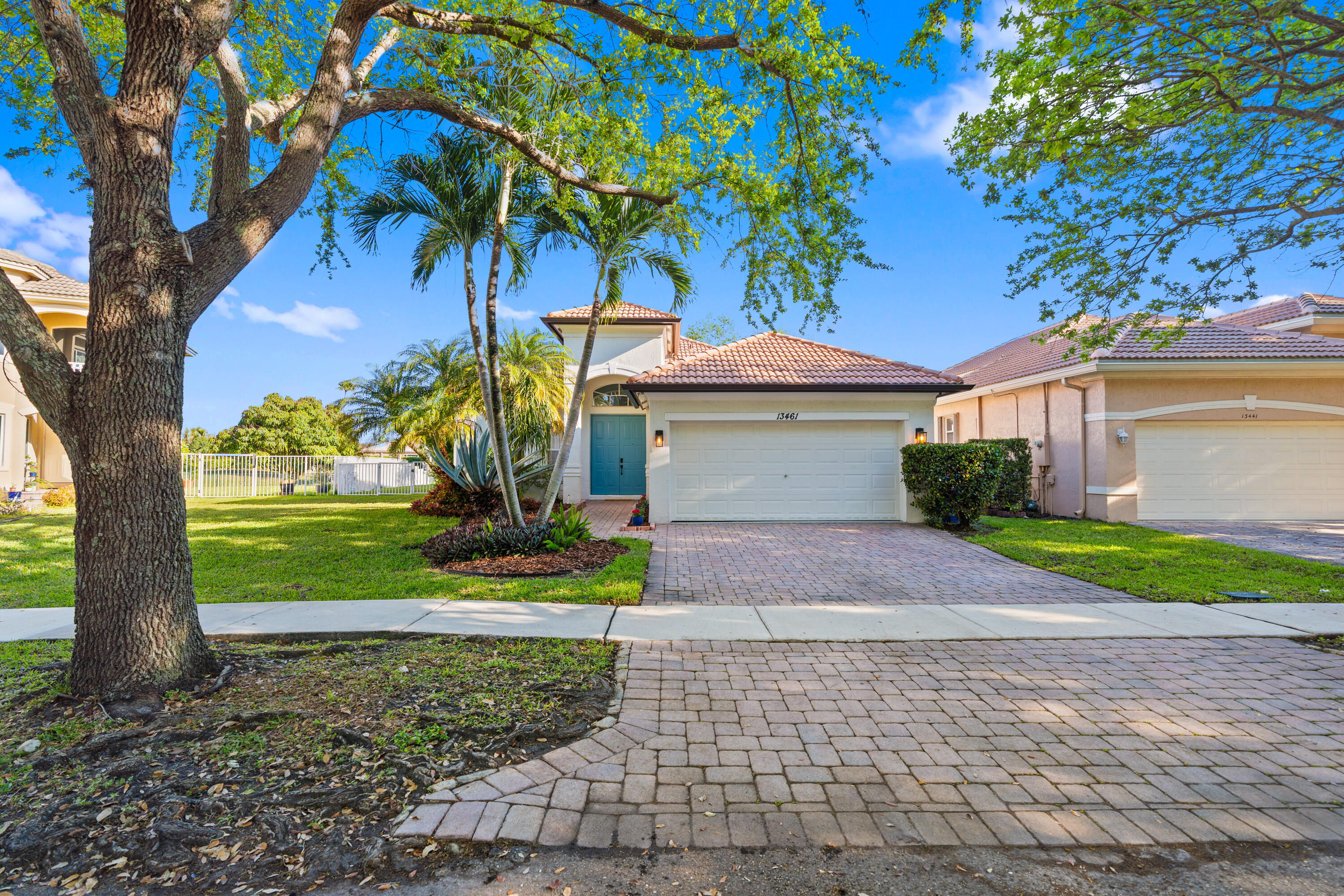 a front view of a house with a yard and tree