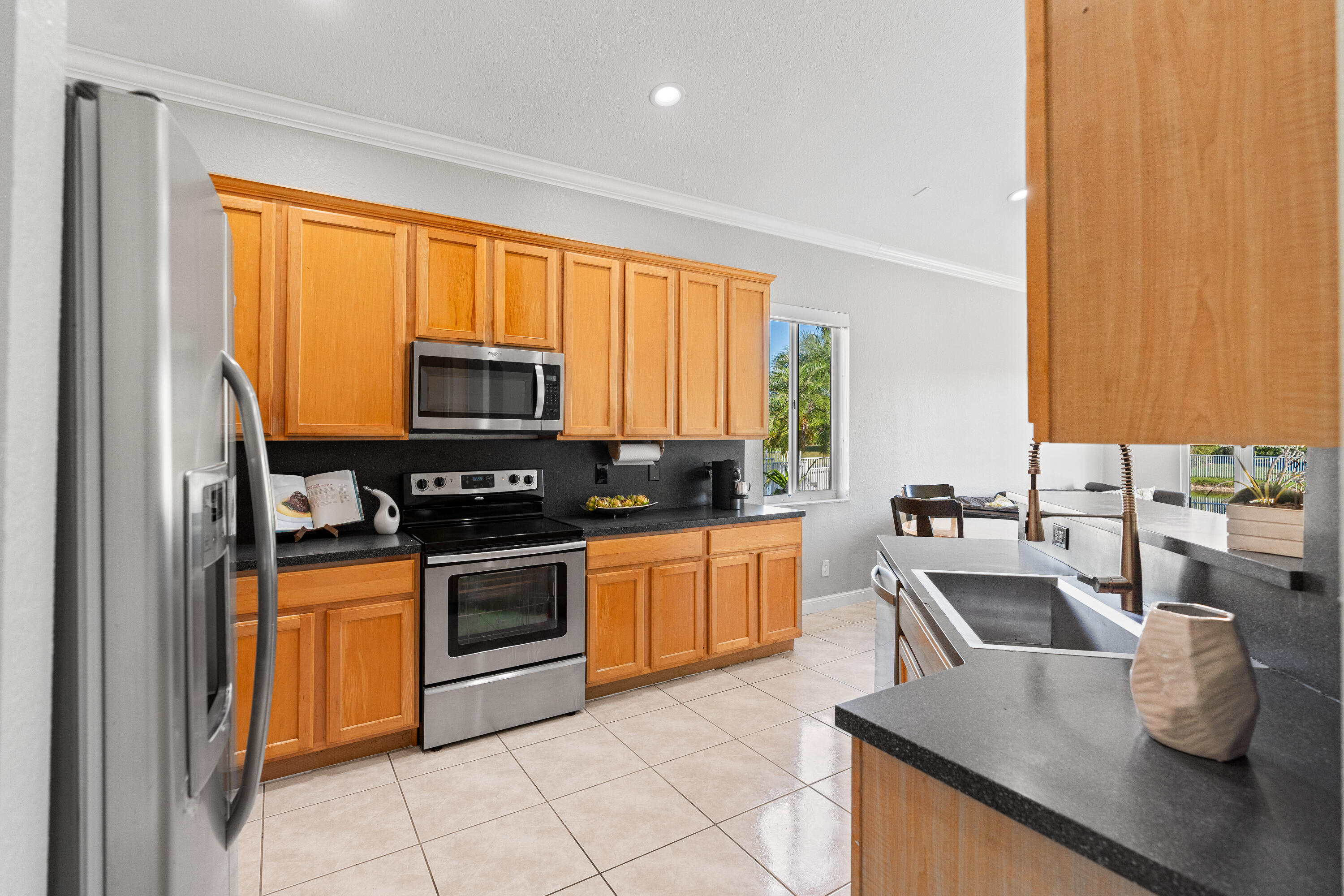 13461 Southwest 29th Street Miramar, FL 33027 - Photo 21 of 54 a kitchen with granite countertop a sink and a stove top oven