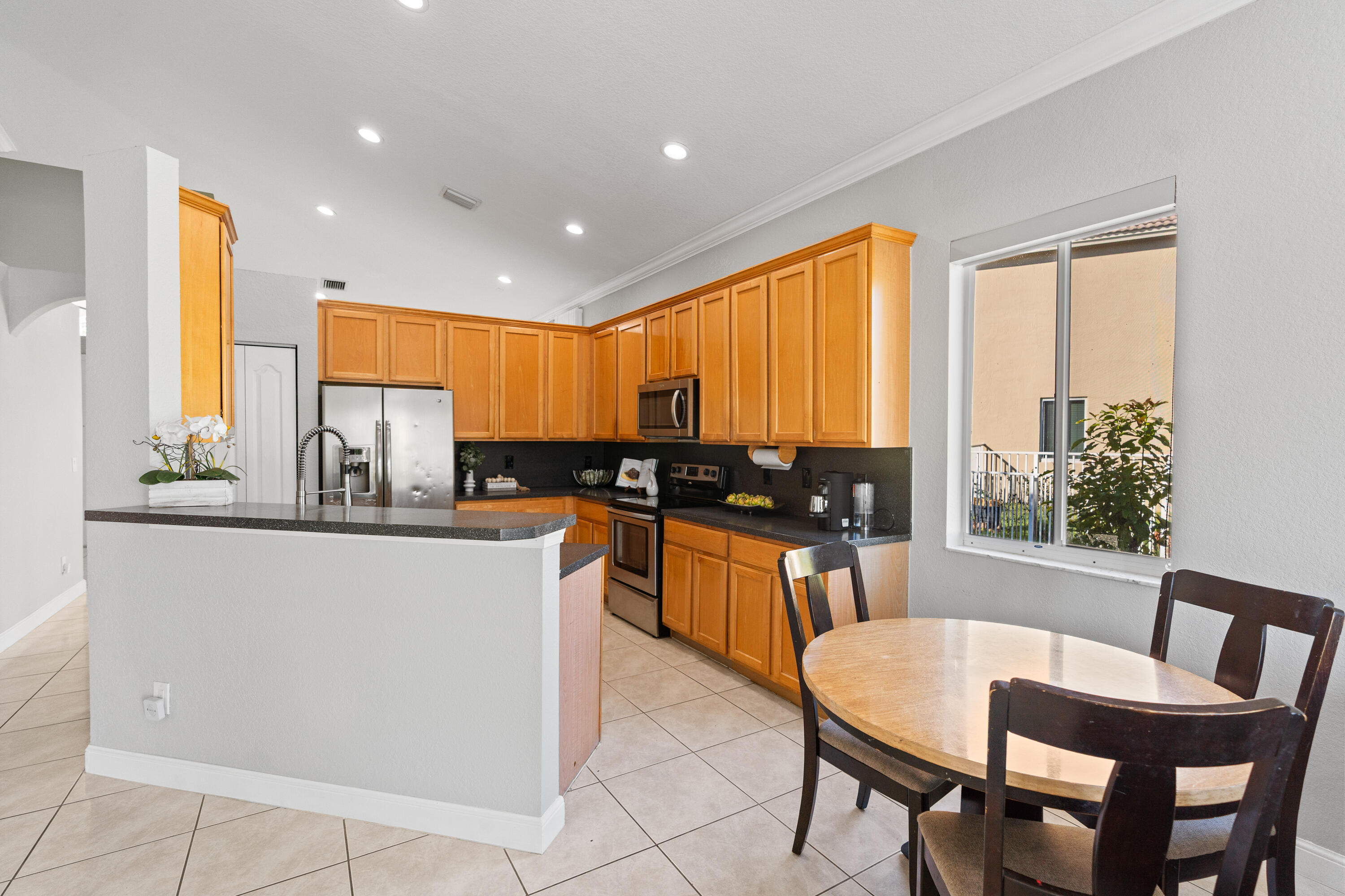 13461 Southwest 29th Street Miramar, FL 33027 - Photo 22 of 54 a kitchen with stainless steel appliances granite countertop sink microwave and wooden floor