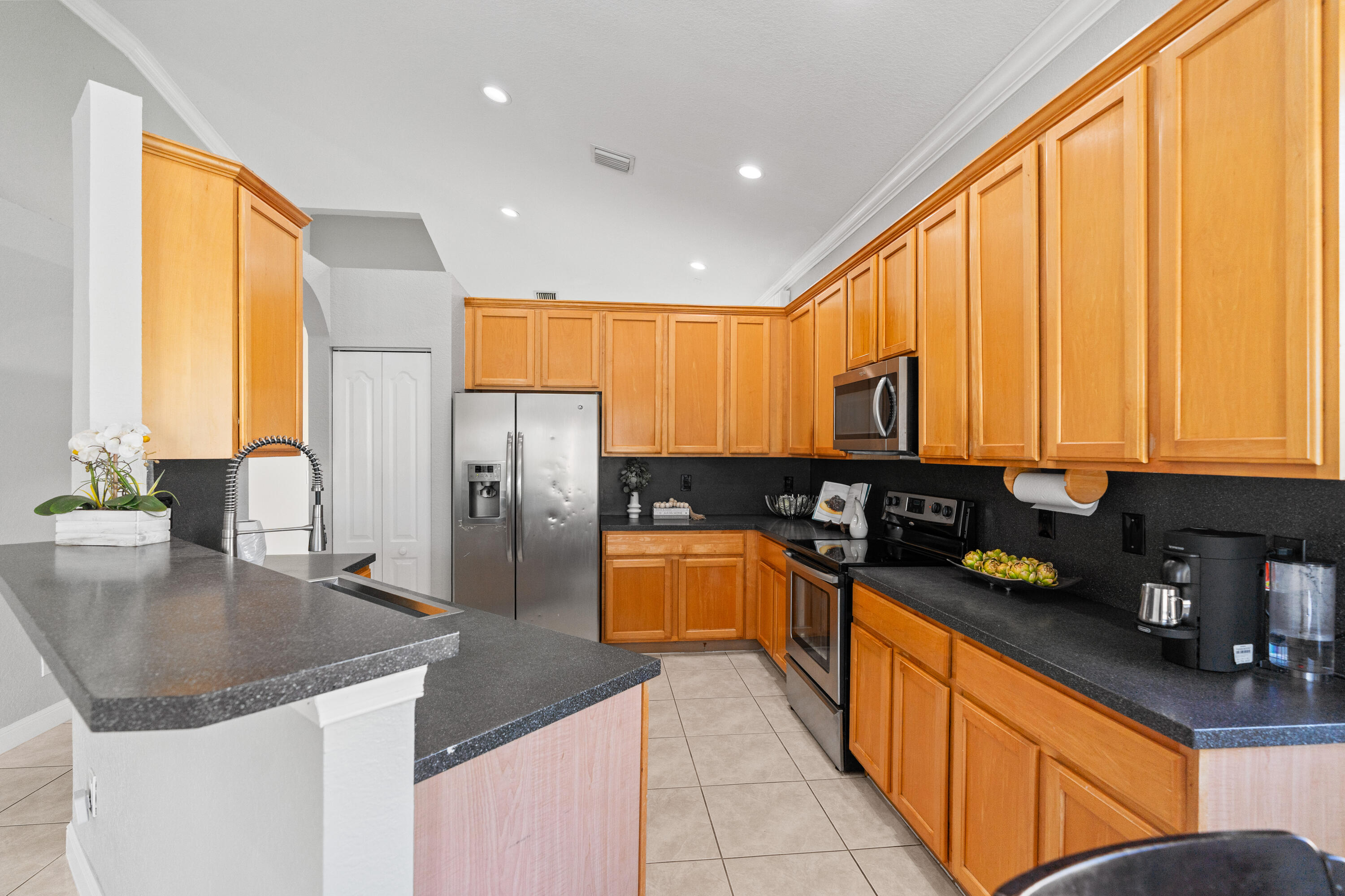 13461 Southwest 29th Street Miramar, FL 33027 - Photo 23 of 54 a kitchen with stainless steel appliances granite countertop a sink a stove and a refrigerator