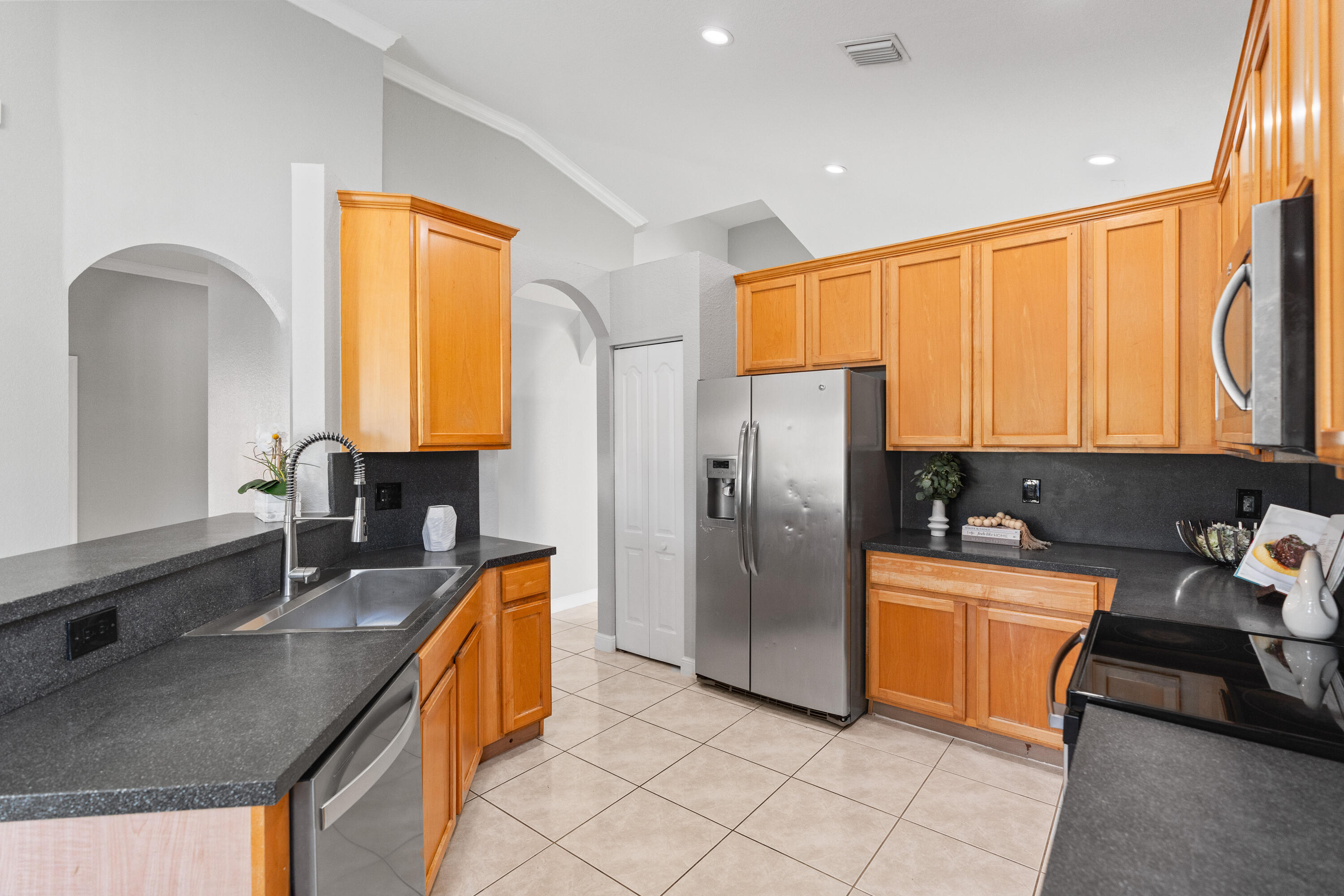 13461 Southwest 29th Street Miramar, FL 33027 - Photo 24 of 54 a kitchen with stainless steel appliances granite countertop a sink a stove and refrigerator