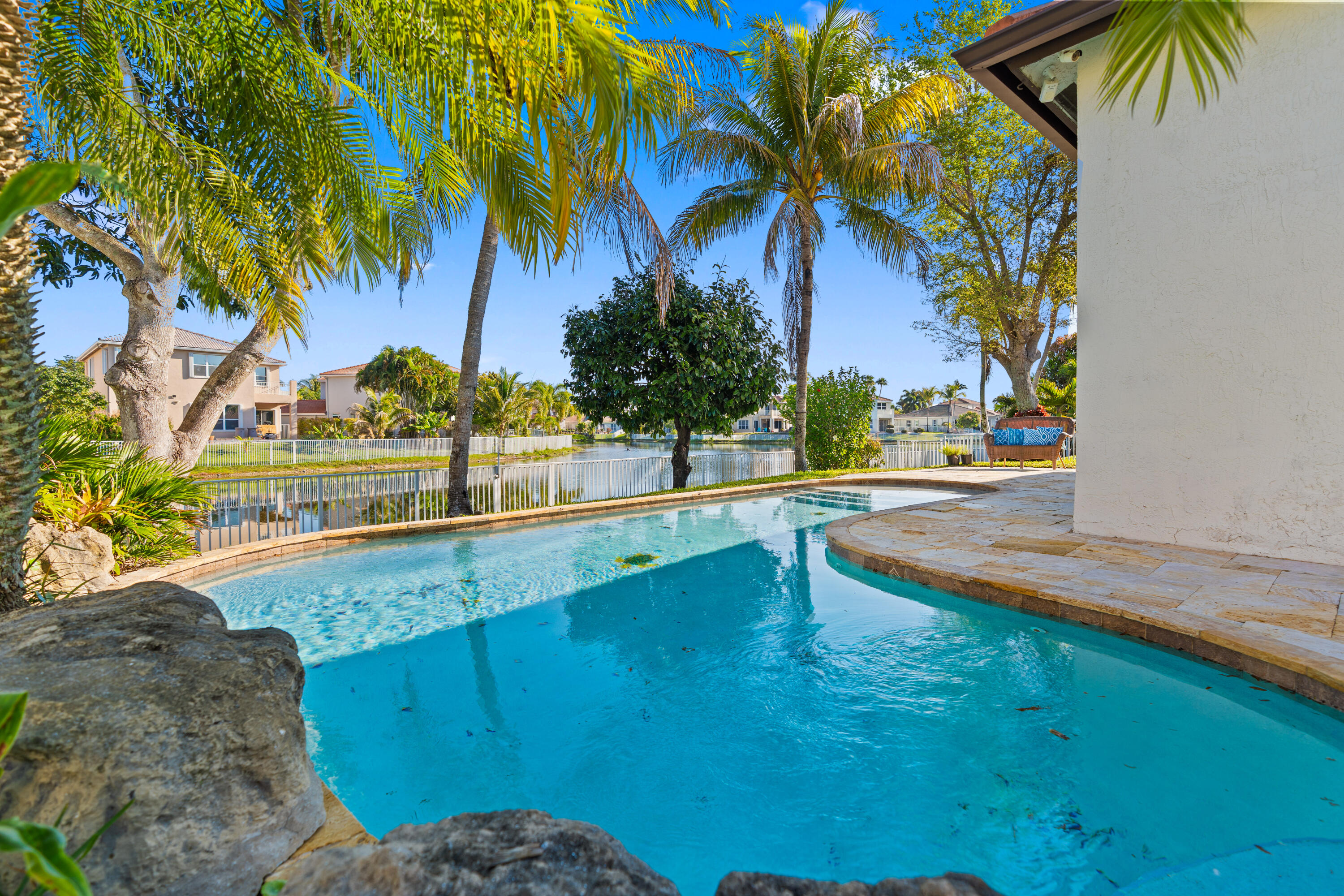13461 Southwest 29th Street Miramar, FL 33027 - Photo 3 of 54 a view of a swimming pool with a lawn chairs under palm trees