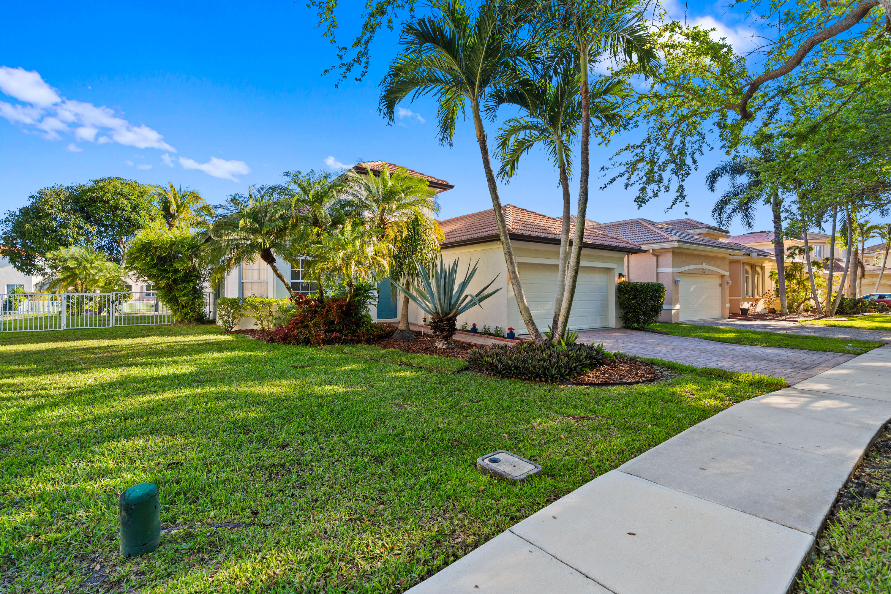13461 Southwest 29th Street Miramar, FL 33027 - Photo 35 of 54 a view of a white house with a big yard and palm trees