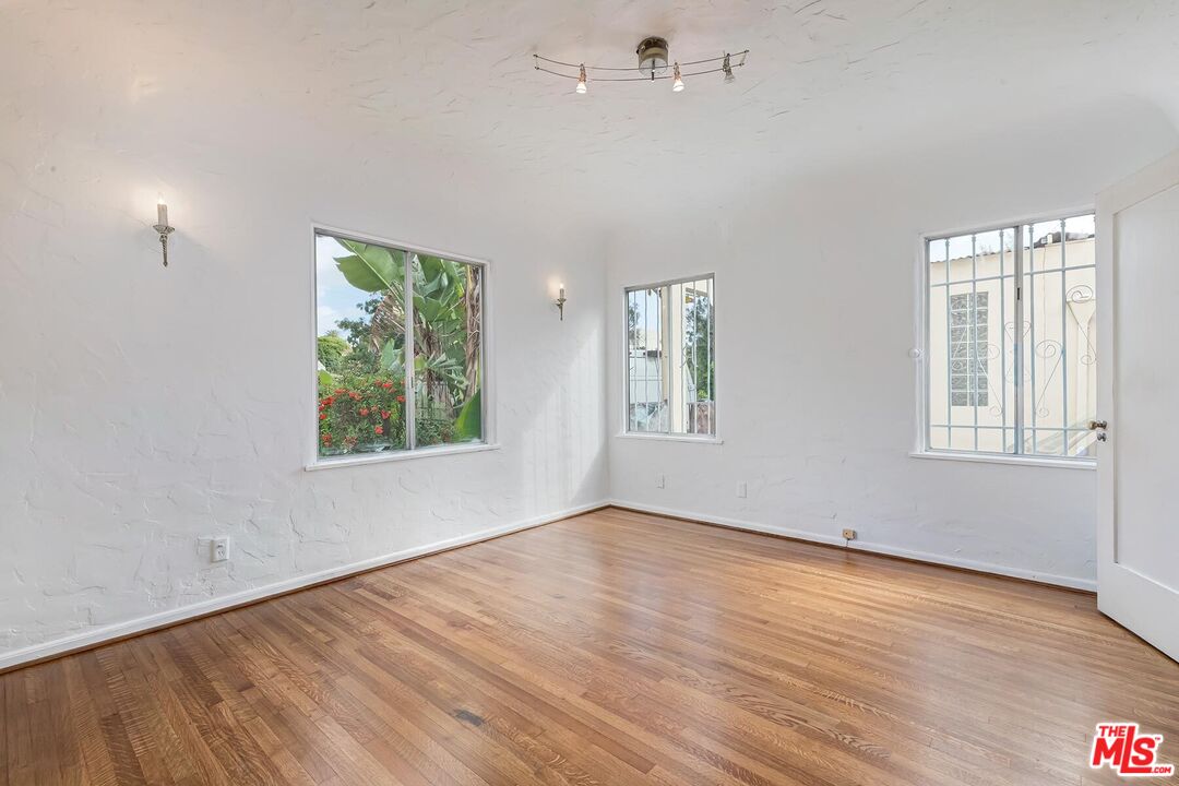 155 Le Doux Road Beverly Hills, CA 90211 - Photo 11 of 12 an empty room with wooden floor and windows