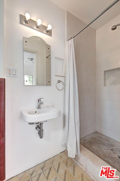 155 Le Doux Road Beverly Hills, CA 90211 - Photo 12 of 12 a bathroom with a sink a mirror and a shower
