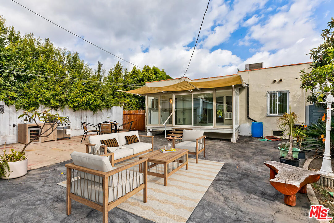 155 Le Doux Road Beverly Hills, CA 90211 - Photo 7 of 12 a view of a patio with couches table and chairs under an umbrella with a barbeque