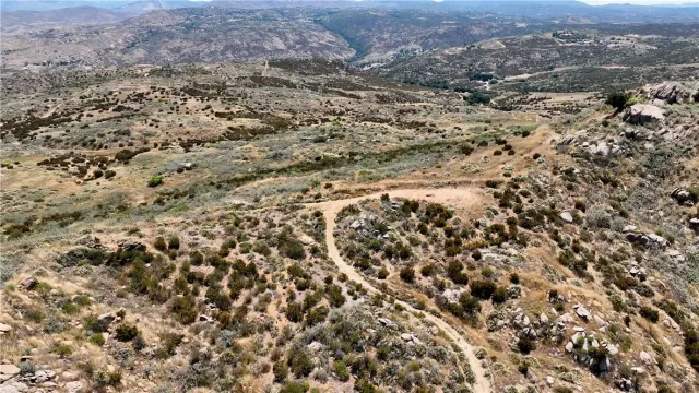 an aerial view of house with yard and mountain view in back