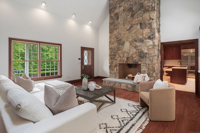 a living room with furniture large window and fireplace