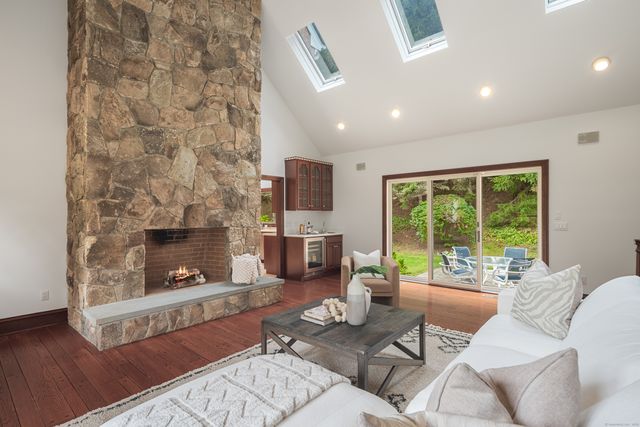 a living room with furniture a fireplace and a floor to ceiling window