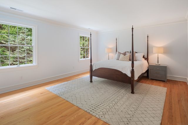 a bedroom with a bed lamp and a large window