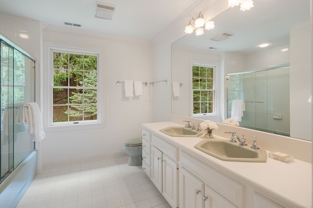 a bathroom with double vanity sink a two mirror and a window