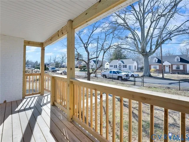 a view of a balcony with chairs and wooden fence
