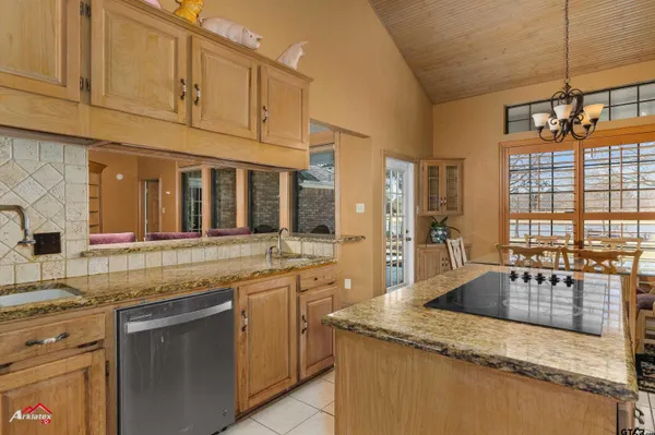 a kitchen with granite countertop a sink stove and cabinets