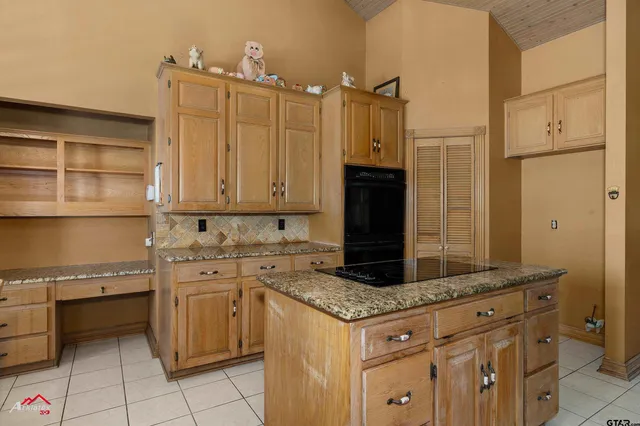 a kitchen with granite countertop a sink stove and cabinets