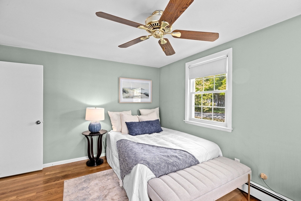 154 Mann Road Scituate, MA 02066 - Photo 16 of 34 a bedroom with a bed wooden floor and a ceiling fan