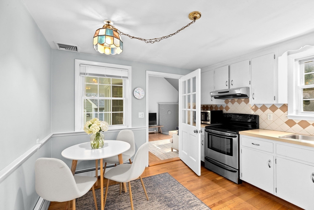154 Mann Road Scituate, MA 02066 - Photo 5 of 34 a kitchen with a stove a table and chairs in it