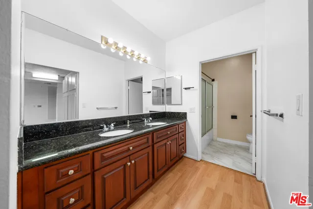 a spacious bathroom with a granite countertop sink a mirror and a shower