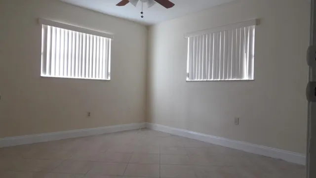 an empty room with a window and a ceiling fan